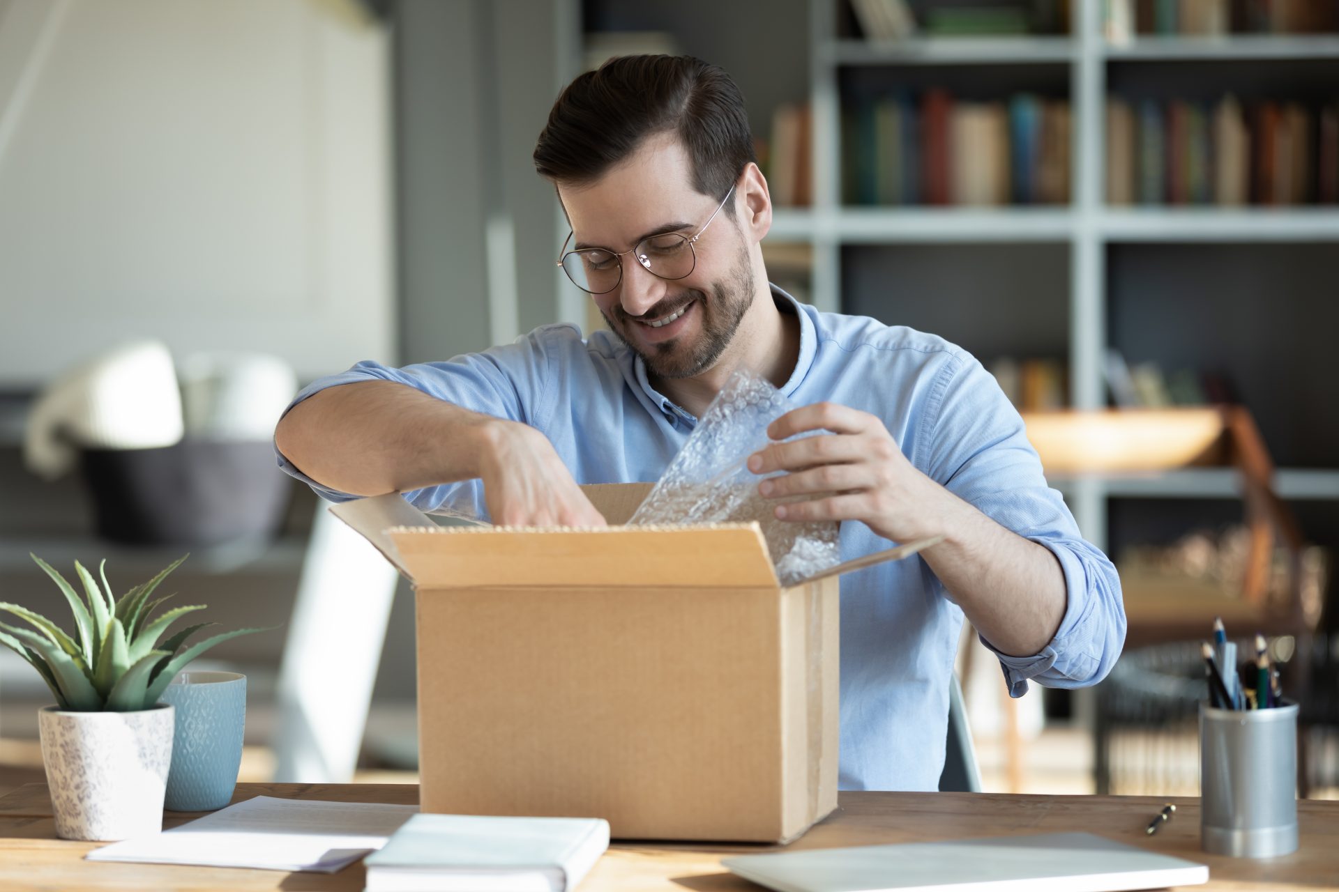 Man receiving package by delivery and opening it